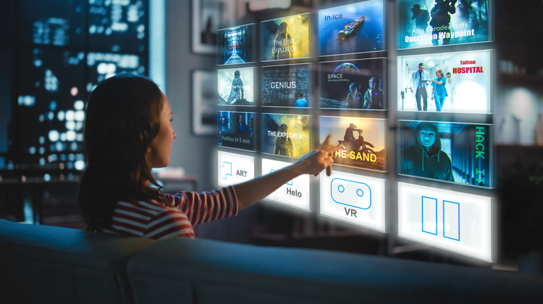 A woman choosing a TV show from a holographic interface