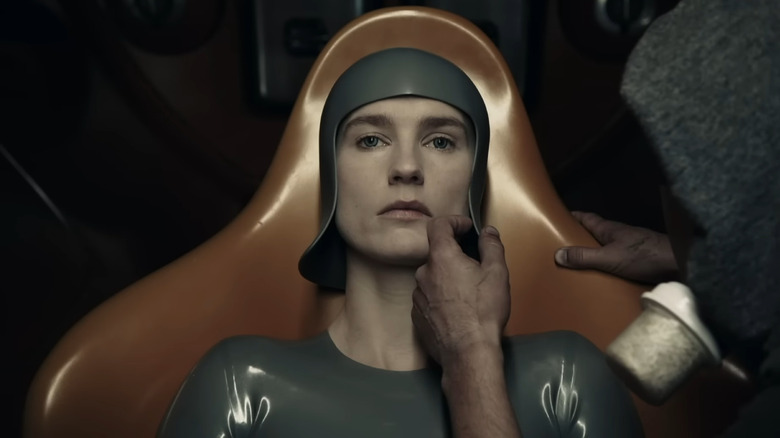 A still from the Raised by Wolves trailer showing a woman seated in a chair while someone attends to her