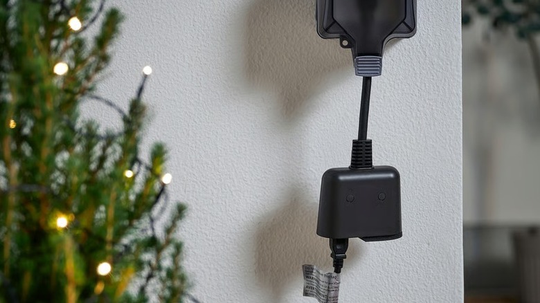 Tofsmygga Smart Outdoor Plug connected to a wall outlet and powering the outdoor lights