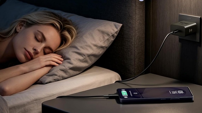 Person sleeping next to nightstand with phone using ANWPF charger