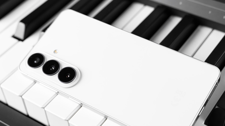 White Galaxy S26 laying on piano keys showing rear of phone