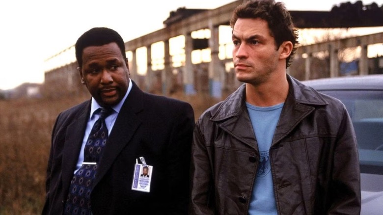 Jimmy McNulty (Dominic West) and Bunk Moreland (Wendell Pierce) sat against a car in The Wire