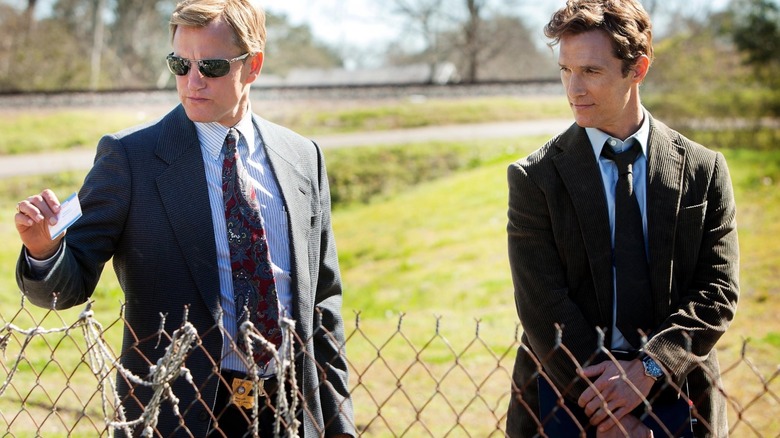 Woody Harrelson's Martin Hart or Matthew McConaughey's Rustin Cohle looking at a fence in True Detective Season 1