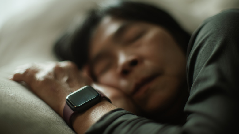 A sleeping person wearing a smartwatch.