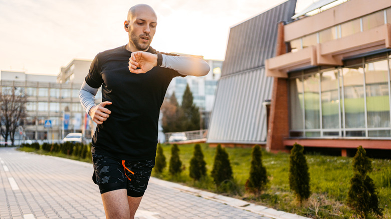 A runner checking his smartwatch.