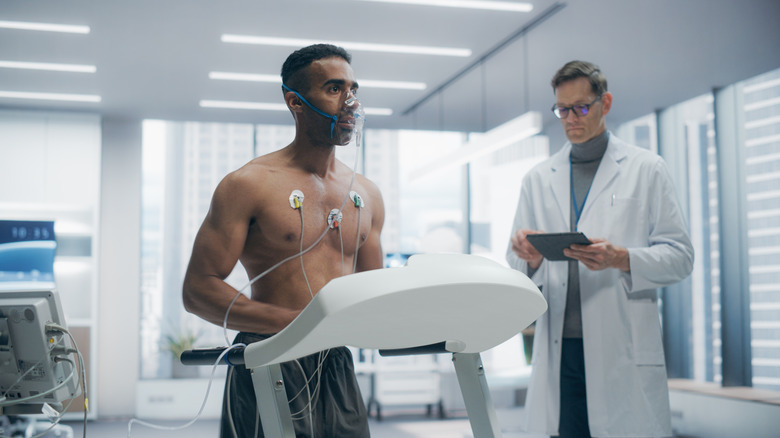 An athlete wearing an oxygen mask in a medical lab.