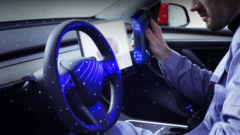 A man 3D scanning a car steering wheel and dashboard with Raptor Pro