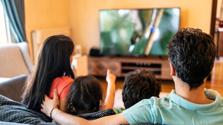 Family watching a show with a blurry smart tv in the background