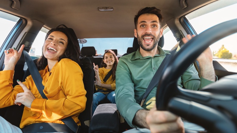 A family enjoying music together in a car.