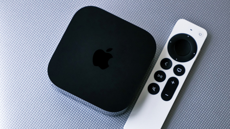 The Apple TV 4K placed next to its Siri remote.