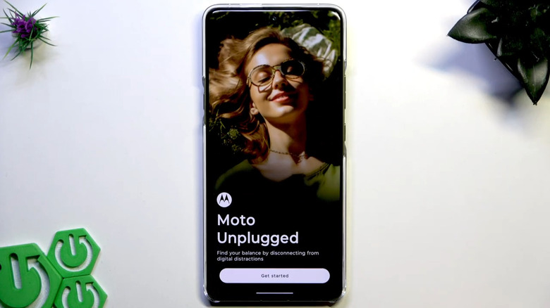 Motorola phone on table showing Moto Unplugged app