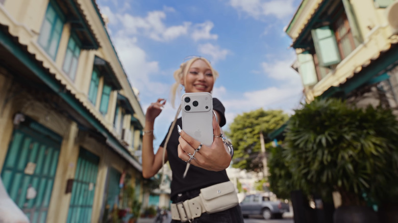 Woman holding iPhone 17 Pro for a selfie