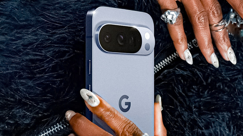 Google Pixel 10 being held on a blur coat background