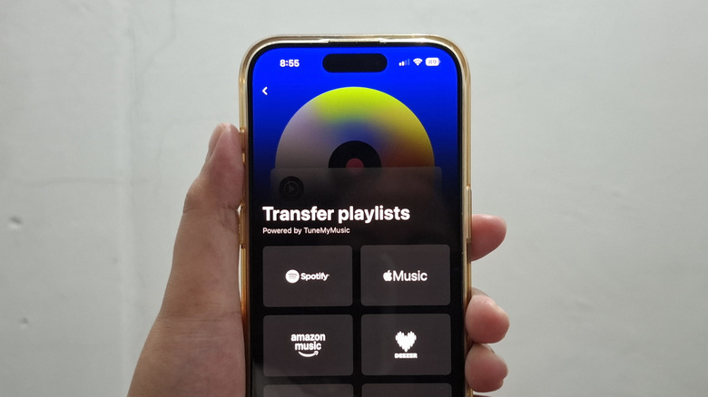 Hand holding phone showing YouTube Music's transfer from Spotify tool