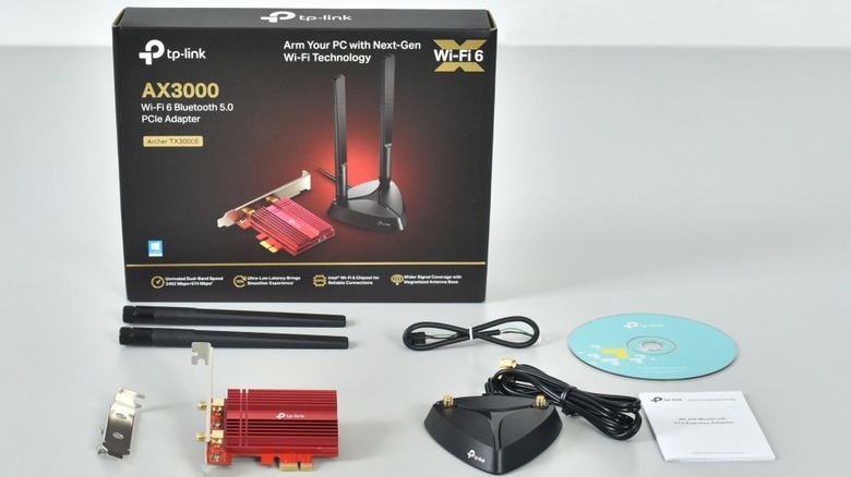 TP-Link Archer TX3000E box with disassembled parts on table