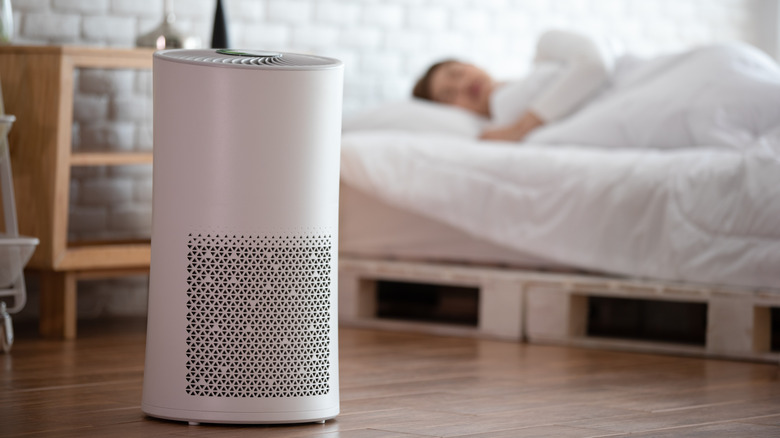 Woman sleeps with Air purifier in cozy white bed room