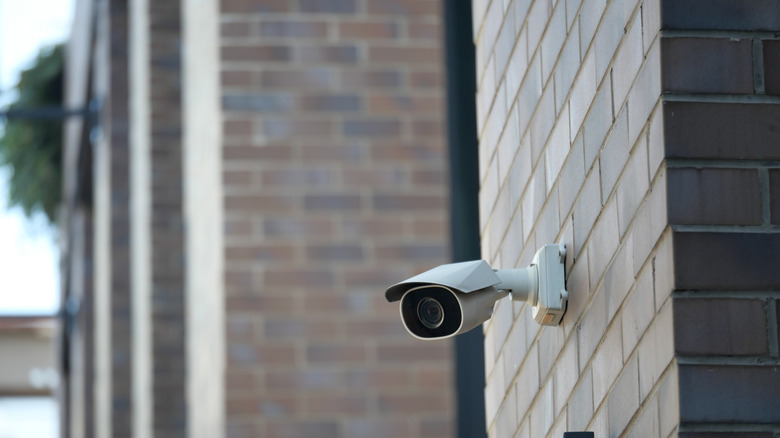 An outdoor camera mounted to a brick facade.