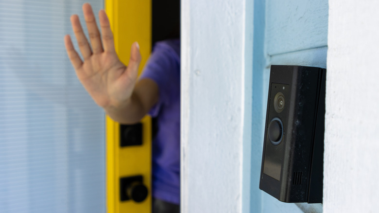 A person sticking their hand out a front door to discourage a solicitor.