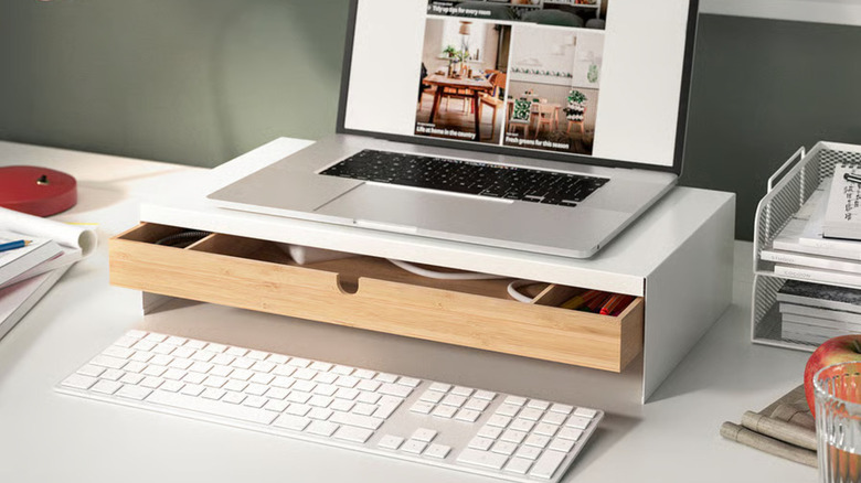 The Elloven Monitor Stand with Drawer placed below a monitor on a desk surrounded by other gadgets