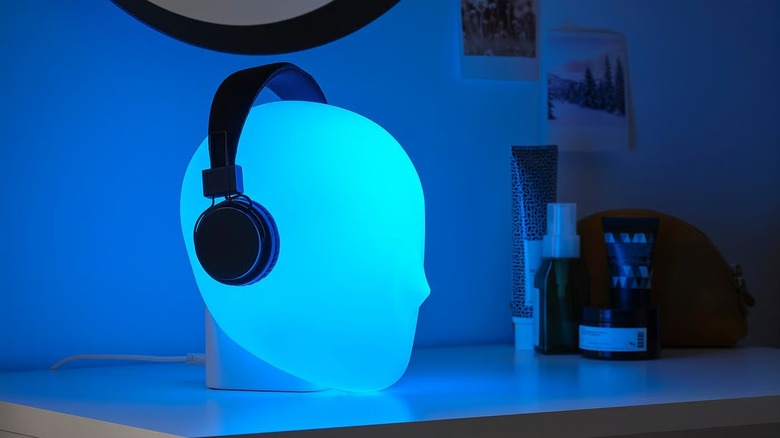 Iskarna LED Table Lamp in color blue with headphones resting on top