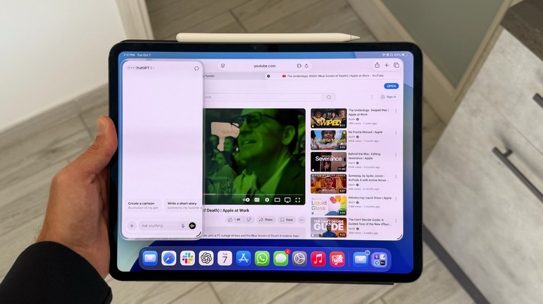 A man holding an iPad Pro with Safari and ChatGPT apps opened up