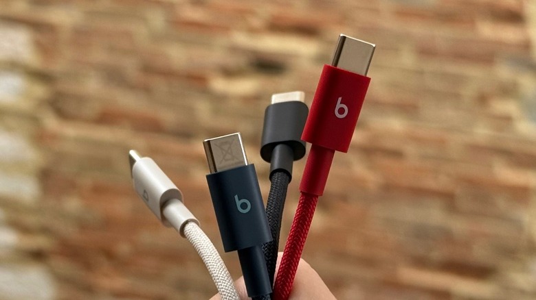 Hand holding several Beats cables