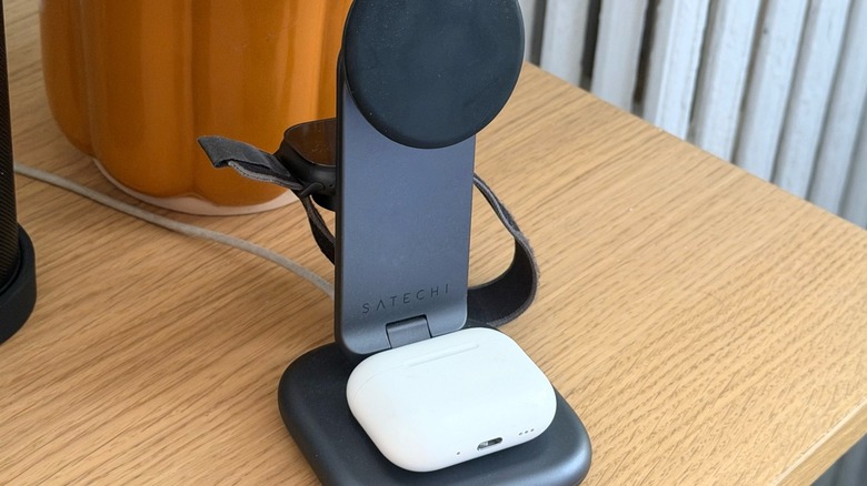 A wireless charging stand with AirPods and Apple Watch on