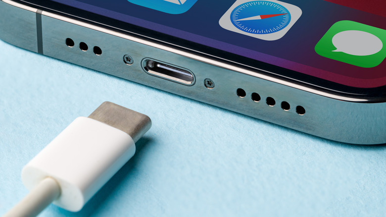 A USB-C cable near an iPhone's USB-C port