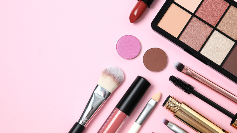 Multiple cosmetics and beauty products on a plain background