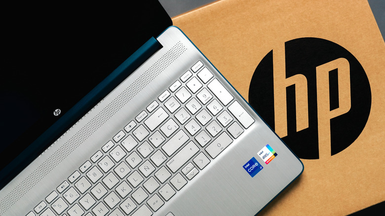 A silver HP laptop open on a box
