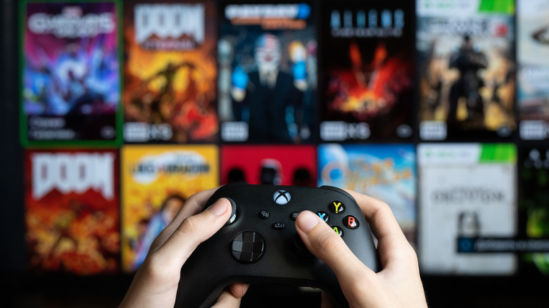 Player holding an Xbox Series X controller scrolling through their game library