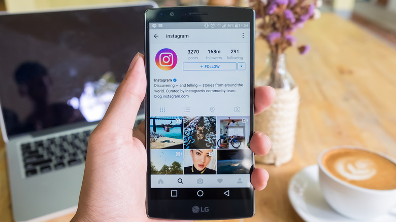 LG G4 held in a hand while showing Instagram on its screen.