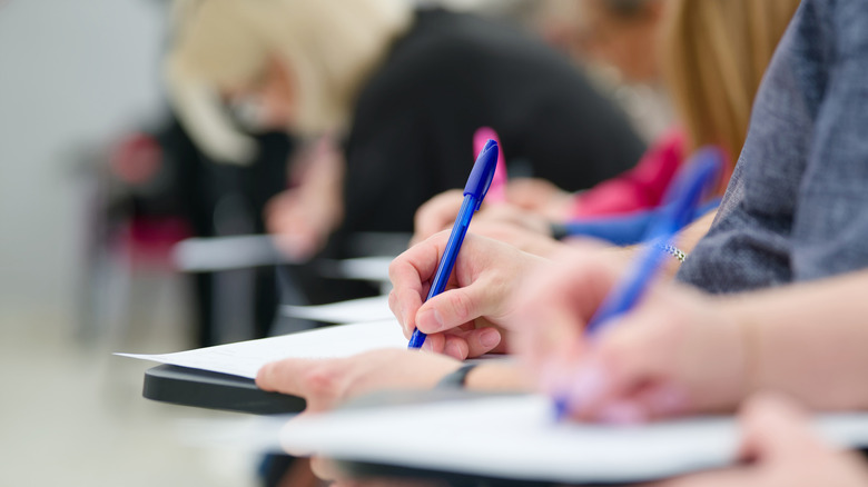 Students taking notes by hand in a classroom