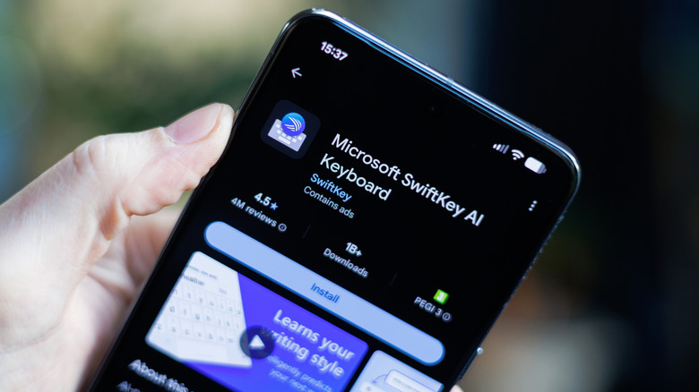 Hand holding a phone displaying the SwiftKey Play Store listing
