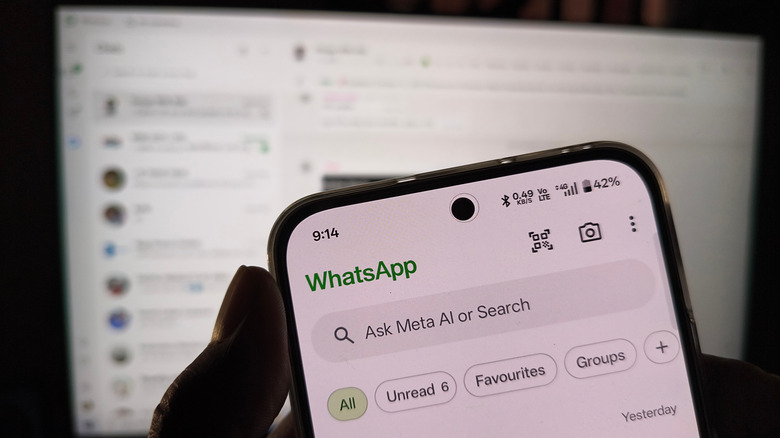 WhatsApp on phone and web blurred in background