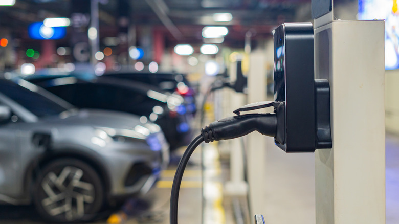 An EV charging station with cars in the background
