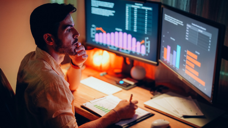 Person working at a desk with two monitors
