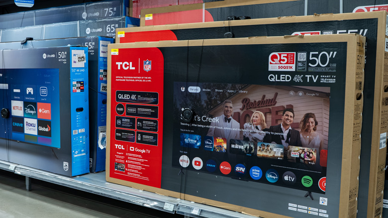 A TCL-brand television in its original packaging on a shelf in a store.