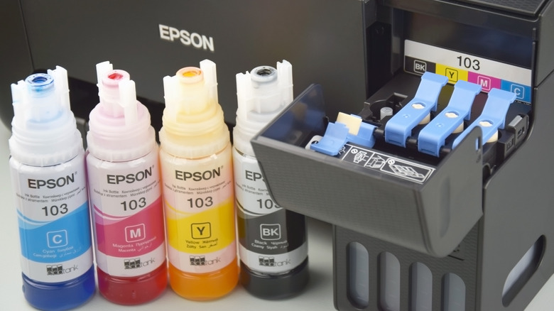 Epson CMYK ink refillers sat in front of an Epson inkjet printer