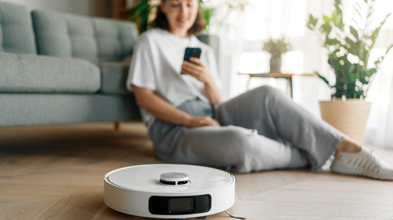 person setting up robot vacuum on smartphone