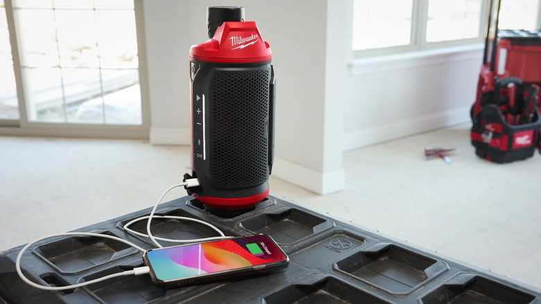 Milwaukee M12 Bluetooth Jobsite Speaker with phone plugged in.