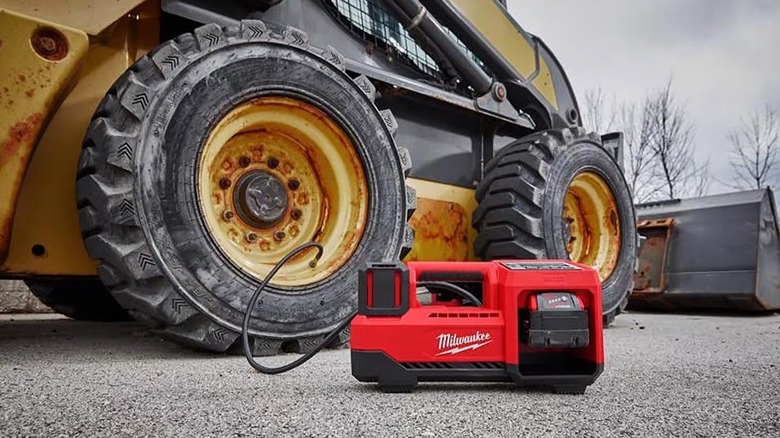 Milwaukee M18 Cordless Tire Inflator plugged into heavy equipment pumping up the tires.