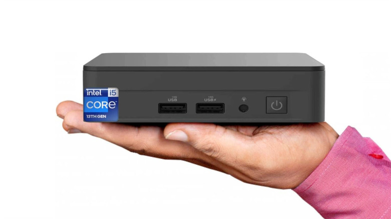 A hand holding the ASUS NUC 13 Pro against a white background