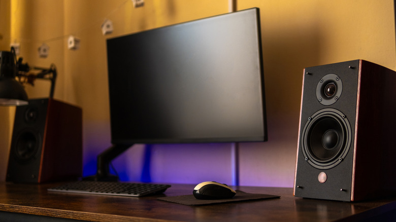 Minimalist desk setup with monitor, speakers, and mouse.