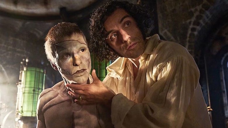 Jacob Elordi as The Creature being guided by Oscar Isaac as Victor Frankenstein