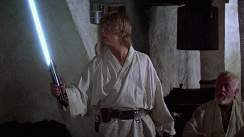 Luke Skywalker holding a lightsaber in Star Wars: A New Hope