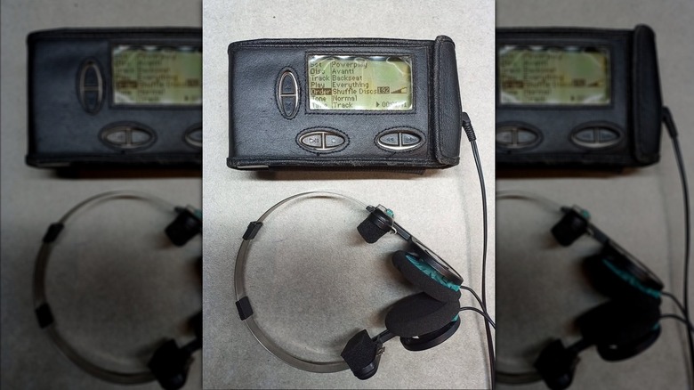 A photo of an Personal Jukebox PJB-100 in a leather case, a pair of headphones are attached to the device