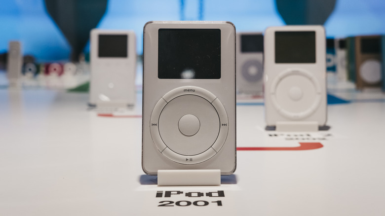 An original 2001 Apple iPod sits in front of several other iPods throughout Apple's history