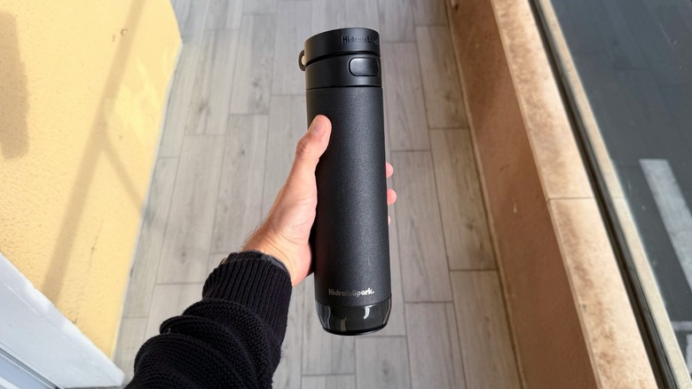 A hand holding the HidrateSpark Pro 2 water bottle