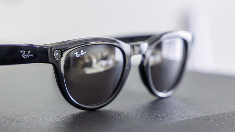 Close-up of black Meta Ray-Ban smart glasses featuring a camera lens and sleek, reflective lenses.